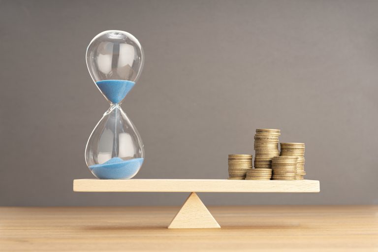 Balance Between Time and money concept. Sand clock and stacked c